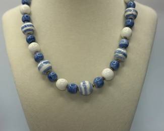 Blue & White Ceramic Necklace. Approximately 17". White, blue and striped beads. Brown braided string.
USA Shipping Only.