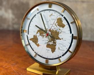 This lot features a Kundo Kieninger & Obergfell world clock, made in West Germany circa 1960s. This clock features quartz movement, elegant gold and white clock face, and a sleek brass case. The clock is designed to allow one to quickly calculate the time in any area of the world. In good working condition and measures, 10” H x 9” W x 4” D.
