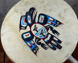 “Tlingit Eagle”, artwork on a drum by listed artist Jerry Lieb, Jr., otherwise known as Sivaluaq circa 2006. This work comes with a mounted handle and measures, 21.75” H x 15” W. Artist and artwork information on the verso as shown in photos.
