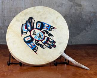 “Tlingit Eagle”, artwork on a drum by listed artist Jerry Lieb, Jr., otherwise known as Sivaluaq circa 2006. This work comes with a mounted handle and measures, 21.75” H x 15” W. Artist and artwork information on the verso as shown in photos.
