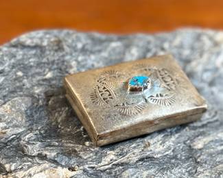 This lot features a vintage Native American pill box, made of sterling silver with a Turquoise center stone. Marked sterling with a total approx. weight of 8.55 grams and measures 1.5” W x 1” D.
