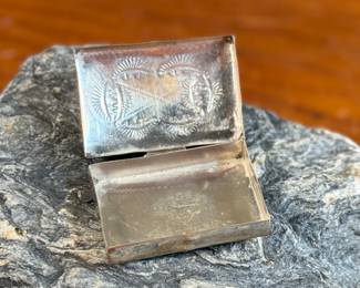 This lot features a vintage Native American pill box, made of sterling silver with a Turquoise center stone. Marked sterling with a total approx. weight of 8.55 grams and measures 1.5” W x 1” D.
