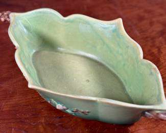 This lot features a Roseville Apple Blossom double handle vase in good overall condition with maker mark present underneath as shown in photos. This vase measures, 3” H x 15.5” W x 8” D.
