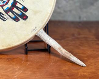 “Tlingit Eagle”, artwork on a drum by listed artist Jerry Lieb, Jr., otherwise known as Sivaluaq circa 2006. This work comes with a mounted handle and measures, 21.75” H x 15” W. Artist and artwork information on the verso as shown in photos.
