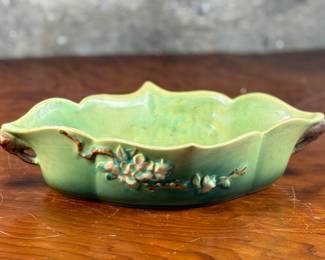This lot features a Roseville Apple Blossom double handle vase in good overall condition with maker mark present underneath as shown in photos. This vase measures, 3” H x 15.5” W x 8” D.
