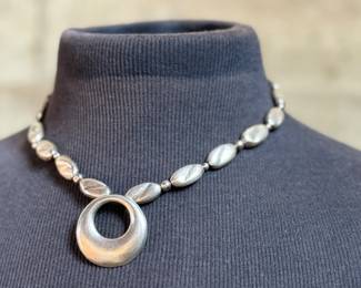 This lot features a beautiful sterling silver necklace with pendant by designer, Avi Soffer. Marked as shown in photos and measures, 18” with a total approx. weight of 48.00 grams. Avi Soffer is an Israeli jewelry designer known for his international perspective and commitment to social impact. He apprenticed with jewelry makers in Israel and Denmark, developing a unique design aesthetic. Soffer is actively involved in supporting human rights causes, including empowerment programs for Arab women in Israel and volunteering at a refugee center. He also mentors new artisans and employs individuals with disabilities in his workshop.
