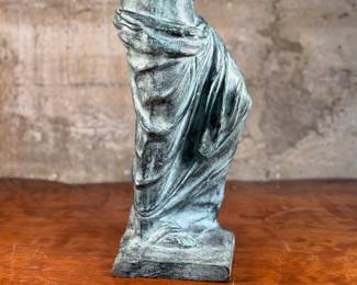 This lot features a famous replica of the Venus de Milo, one of the most famous ancient Greek sculptures. Made in Spain with maker mark near bottom as shown in photos. This sculpture is believed to be made of a hollowed bronze and measures, 24” H x 7.5” W x 7.5” D. The Venus de Milo is a masterpiece of Hellenistic sculpture and is renowned for its idealized beauty and enigmatic appeal, partly due to its missing arms.
