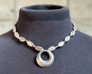 This lot features a beautiful sterling silver necklace with pendant by designer, Avi Soffer. Marked as shown in photos and measures, 18” with a total approx. weight of 48.00 grams. Avi Soffer is an Israeli jewelry designer known for his international perspective and commitment to social impact. He apprenticed with jewelry makers in Israel and Denmark, developing a unique design aesthetic. Soffer is actively involved in supporting human rights causes, including empowerment programs for Arab women in Israel and volunteering at a refugee center. He also mentors new artisans and employs individuals with disabilities in his workshop.
