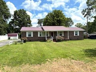 Renovated low-maintenance home with double carport, paved drive, metal roof, replacement windows, ch/a, luxury vinyl tile, and new carpeting. Offers a den w/fireplace, separate dining room, laundry room, eat-in kitchen, dog run, and storage building, all situated on a large lot.