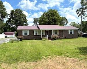 Renovated low-maintenance home with double carport, paved drive, metal roof, replacement windows, ch/a, luxury vinyl tile, and new carpeting. Offers a den w/fireplace, separate dining room, laundry room, eat-in kitchen, dog run, and storage building, all situated on a large lot.