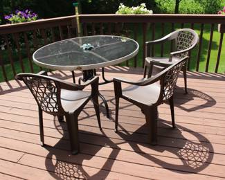 Glass top table and four plastic chairs