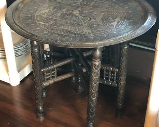 Table with carved folding base & inlaid brass tray top (19” high, tray is 21.5” in diameter)