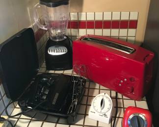 Black & Decker hand mixer, Oster blender, red KitchenAid toaster, timers 
