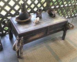 Rustic wooden trunk with carved elephants at the corners - hinges on long end. Was used on outdoor covered porch (45”L, 26”D, 17”H)