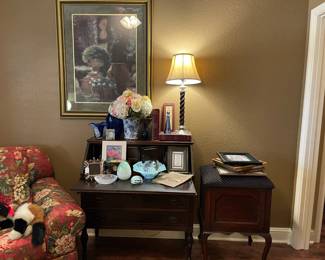 Looking across the living room you will find this antique writing desk with lots of storage, art pieces, floral, barley twist lamp, vintage books, art glass. Storage seat