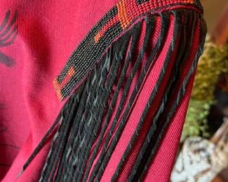 Fringe and bead details on the red jacket