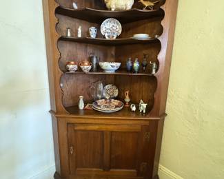 Early 19th century VA/MD walnut corner china cabinet with scalloped shelves over cabinet door. Pegged, pine back, bracket feet.