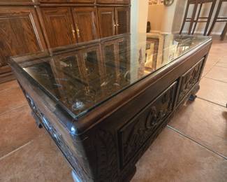 Large ornate coffee table with glass cover