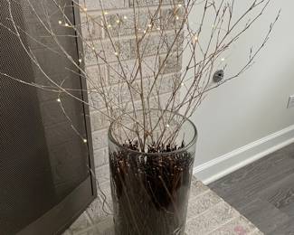 Large glass floor vase with twigs and lights