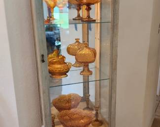 curio cabinet full of amber glass