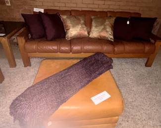 Leather ottoman, throw and pillows.