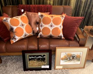 Throw pillows, round end table, framed prints.