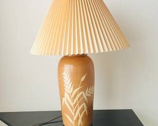 1970s ceramic table lamp, featuring a brown decorative base with leaf patterns and a pleated fabric shade