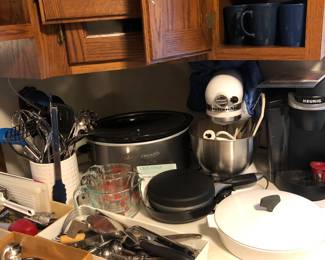 White kitchen aid, mixer with attachments and cover. Large and small crockpots, crepe maker, 2 keurig coffee makers, loads of kitchen, tools, etc.