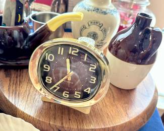 Vintage desk clock with small collectible bottles on wooden tray