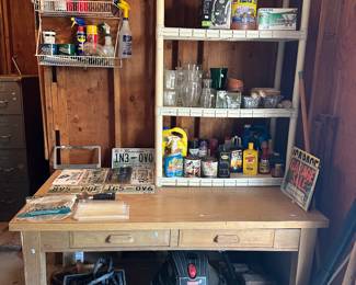Wood workbench with shop vac and shelves of paint supplies