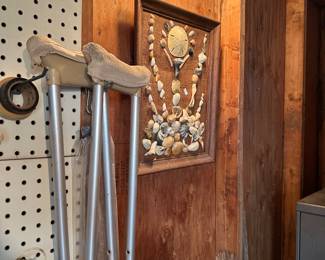 Pair of aluminum crutches and carved wood wall plaque