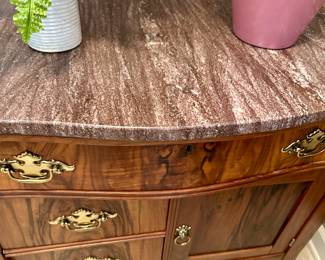 Close up of marble top dresser with brass hardware