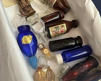 Collection of vintage miniature perfume and cologne bottles in assorted shapes and colors; charming display pieces or craft supply.