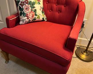 Red tufted loveseat chair with floral pillow