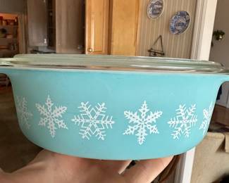 Vintage turquoise Pyrex casserole dish featuring white snowflake motif; classic mid-century kitchen collectible.