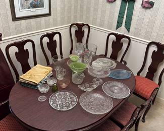 Mahogany oval dining table with six chairs and glass plates