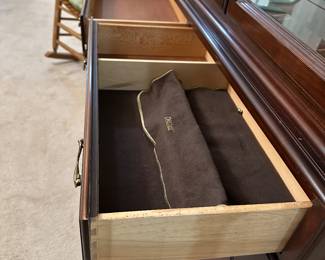 Felt-lined jewelry drawers inside wooden cabinet provide protective storage for valuables.