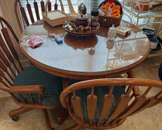 Round glass-top dining table with four rattan chairs