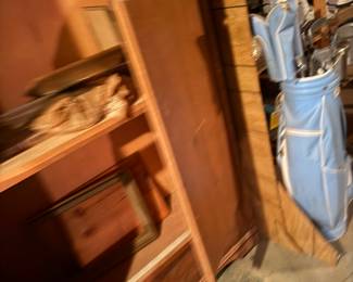 Wood cabinet, large picture frames, golf clubs ladies.