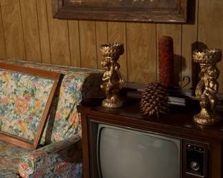 Old tv, candle holders and wall pictures.