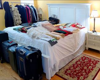 Queen Sized Bed, lots of linens, fine clothing.