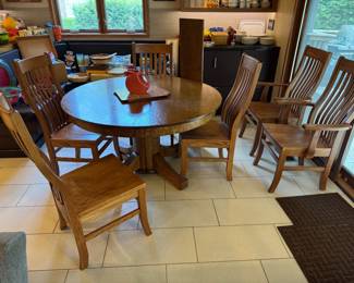 Beautiful 52" solid oak pedestal round table with 1 additional 11' leaf, paired with 6 Amish-made, solid oak, oversized chairs, two of them armed. High-Quality set.