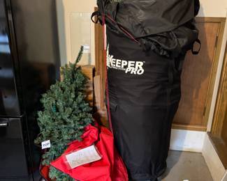 2 artificial Christmas trees, one is in a "tree keeper pro" zip up bag on wheels (the best!)