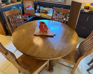 Beautiful 52" solid oak pedestal round table with 1 additional 11' leaf, paired with 6 Amish-made, solid oak, oversized chairs, two of them armed. High-Quality set.