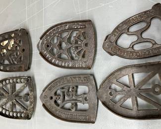 Six Cast Metal Iron Trivets with Various Patterns and Markings
