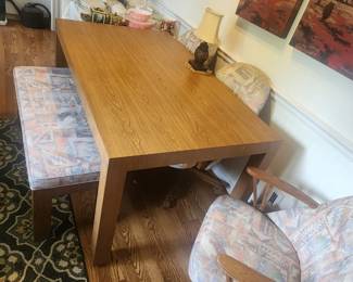 Solid table with chairs on casters and a matching bench.