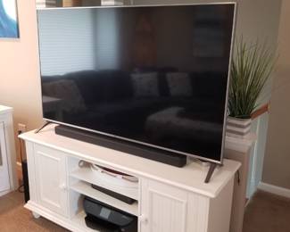 Flat screen TV; sound bar; white entertainment console