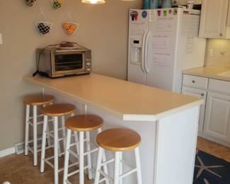 Tidy white L-shaped kitchen with peninsula