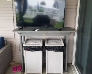 Flat screen TV; Polywood table; wastebaskets