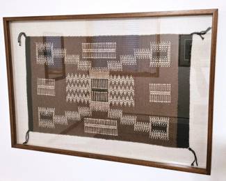 Beautiful old Navajo Rug framed behind glass.